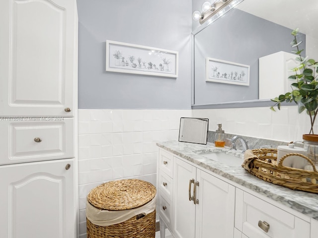 bathroom featuring vanity and tile walls