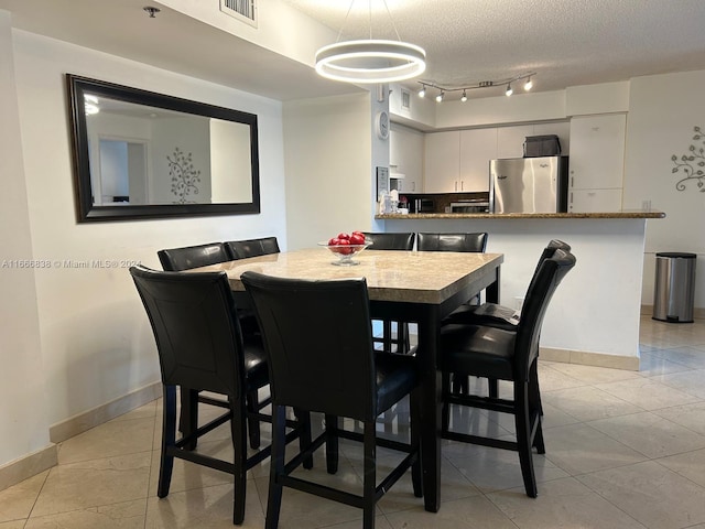 tiled dining room featuring a textured ceiling