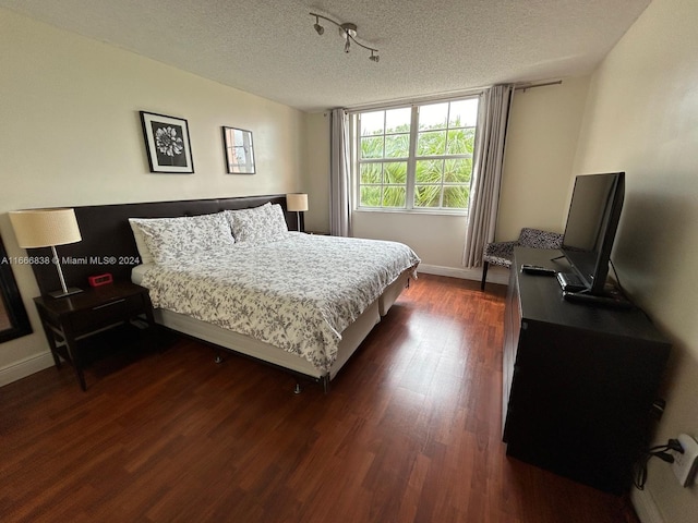 bedroom with dark hardwood / wood-style flooring and a textured ceiling