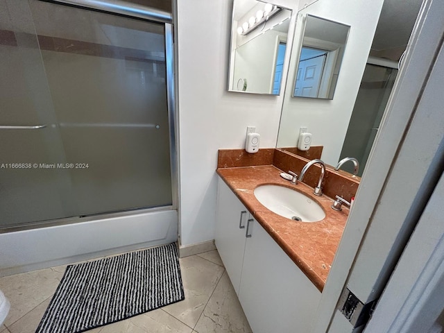 bathroom with bath / shower combo with glass door and vanity