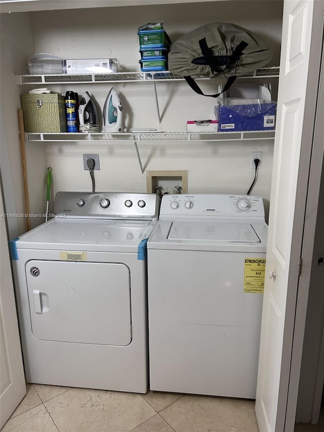 washroom with separate washer and dryer and light tile patterned floors