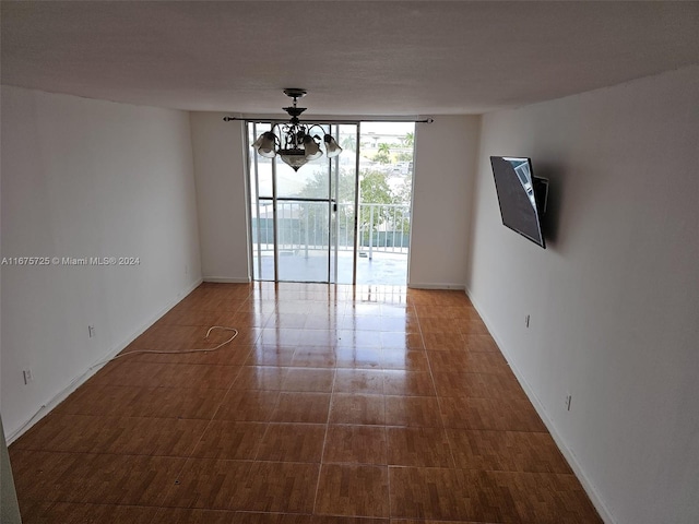 interior space with baseboards, floor to ceiling windows, and a notable chandelier