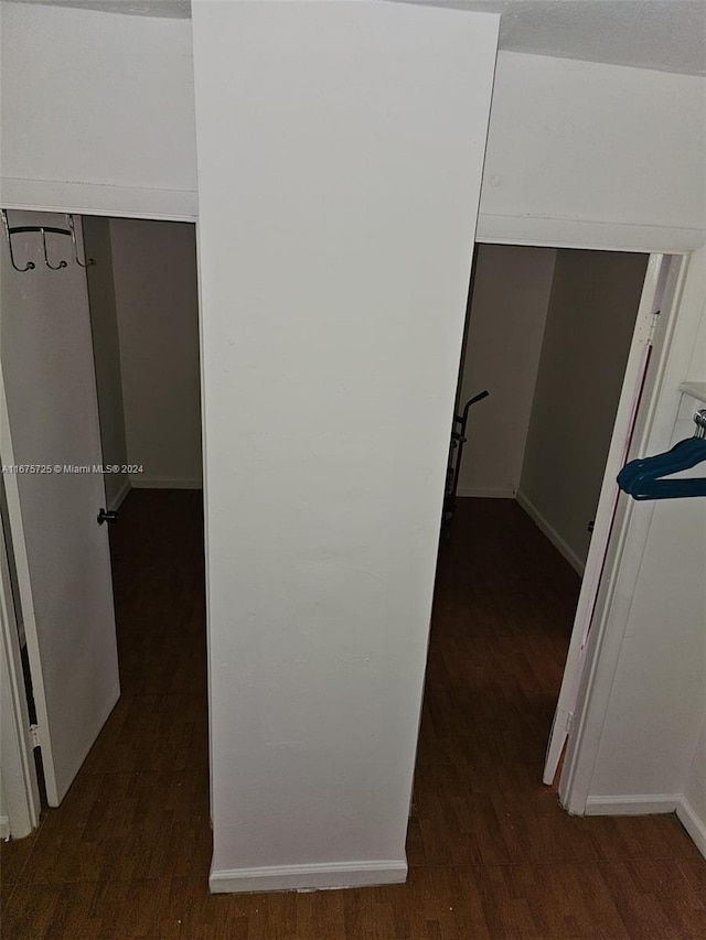 hallway featuring baseboards and dark wood-style floors