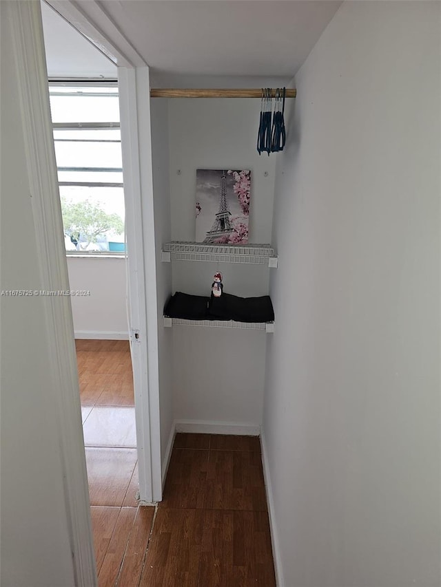 hall featuring baseboards and wood finished floors