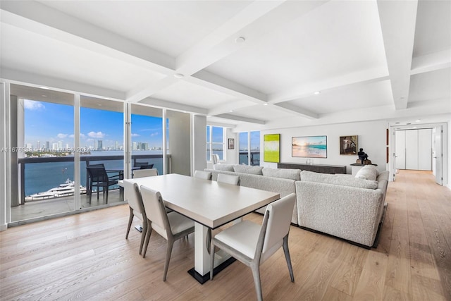 dining area featuring a water view, light hardwood / wood-style floors, beam ceiling, and coffered ceiling