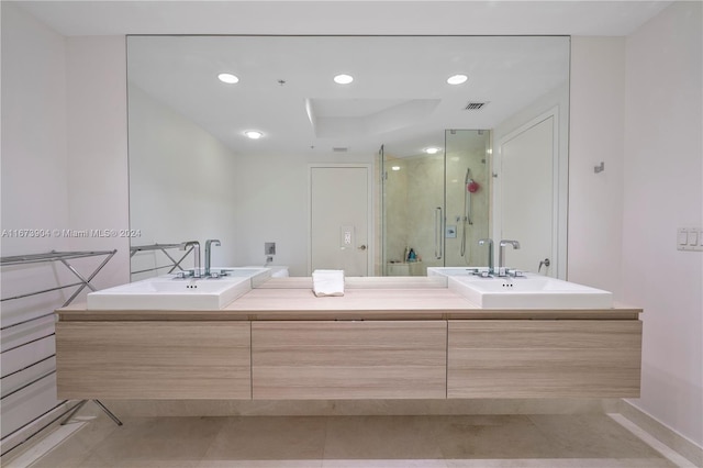 bathroom featuring tile patterned floors, a shower with shower door, and vanity