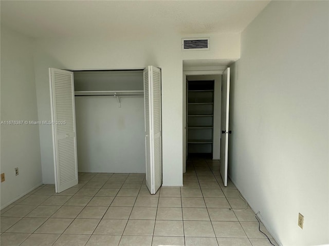 unfurnished bedroom featuring light tile patterned floors and a closet