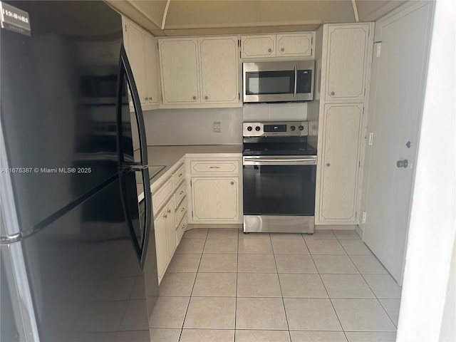 kitchen featuring stainless steel appliances and light tile patterned flooring