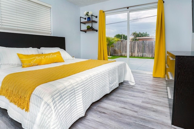 bedroom with access to outside and hardwood / wood-style flooring