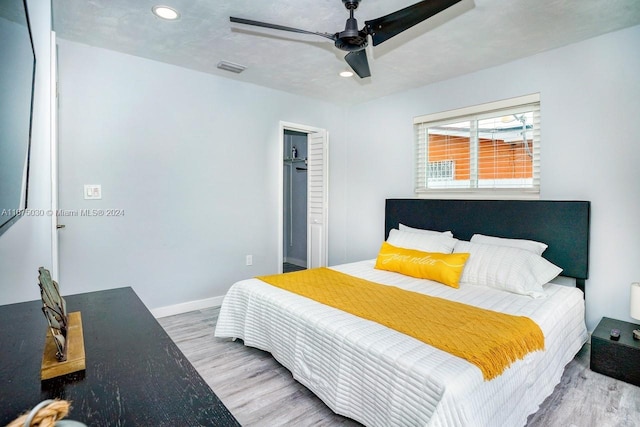 bedroom featuring ceiling fan, a closet, light hardwood / wood-style floors, and a textured ceiling