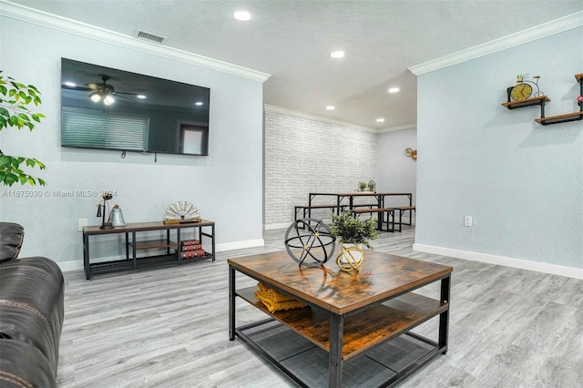 living room with ceiling fan, light hardwood / wood-style flooring, and crown molding