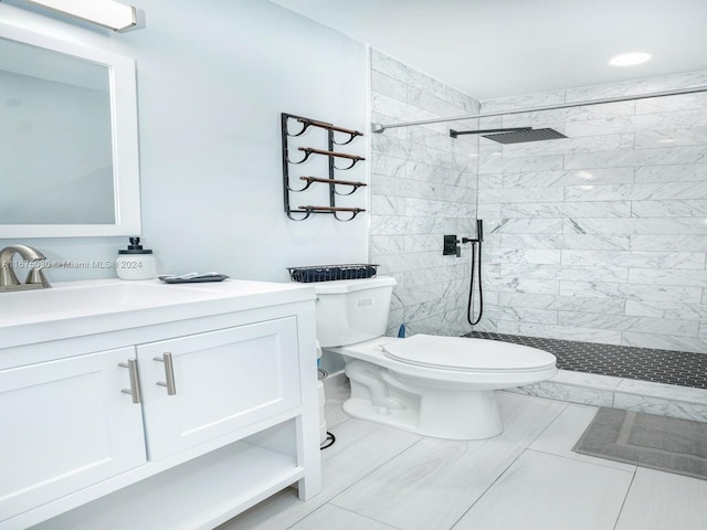 bathroom featuring vanity, toilet, tile patterned flooring, and a tile shower