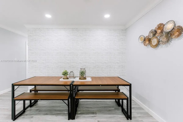 dining area featuring ornamental molding, brick wall, and hardwood / wood-style floors