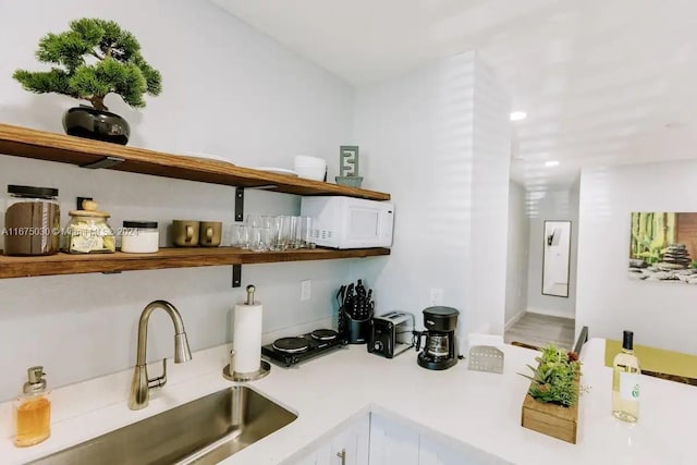 bar with white cabinets and sink