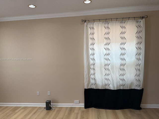 empty room with wood-type flooring and crown molding