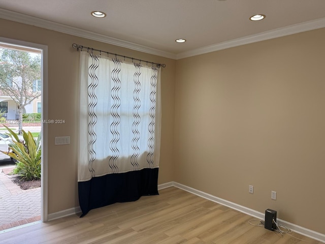 spare room featuring hardwood / wood-style flooring and crown molding