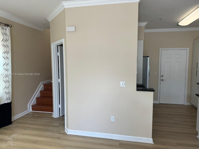 spare room with light hardwood / wood-style floors and crown molding