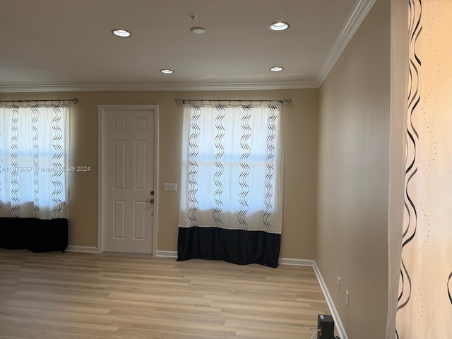 entryway with ornamental molding and light hardwood / wood-style floors