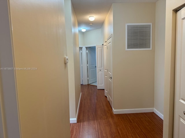 corridor featuring hardwood / wood-style flooring and a textured ceiling