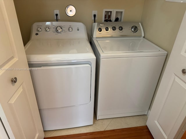 clothes washing area with light hardwood / wood-style flooring and independent washer and dryer