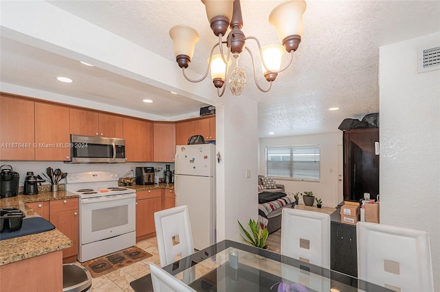 kitchen with hanging light fixtures, light tile patterned floors, a textured ceiling, a chandelier, and white appliances