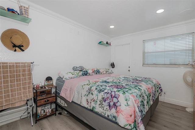 bedroom with ornamental molding and light wood-type flooring