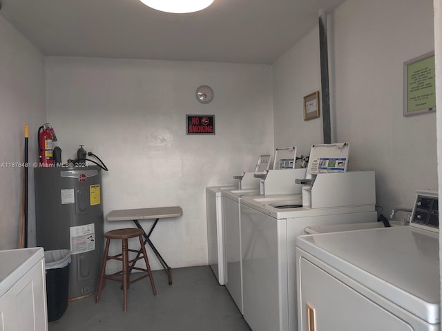 laundry room with electric water heater and washer and dryer