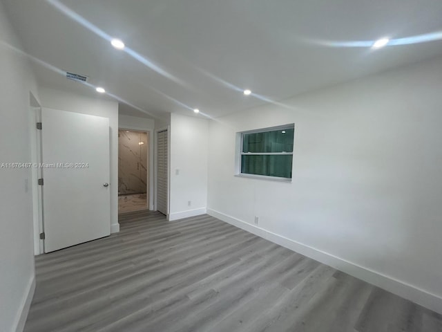 empty room featuring hardwood / wood-style flooring and vaulted ceiling