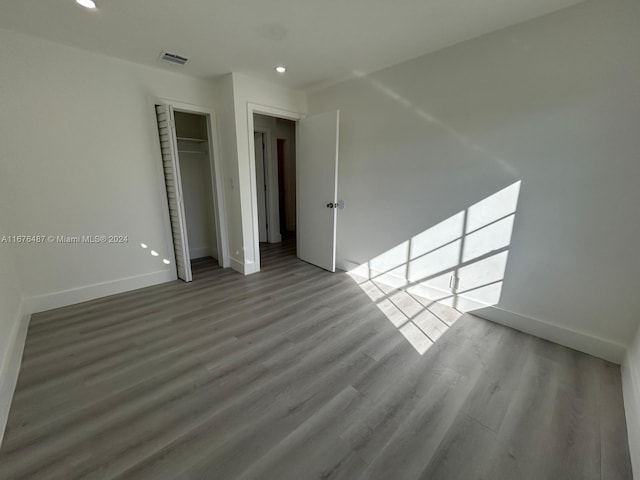 unfurnished room with wood-type flooring