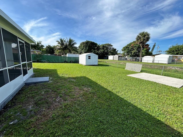 view of yard with a sunroom and a shed