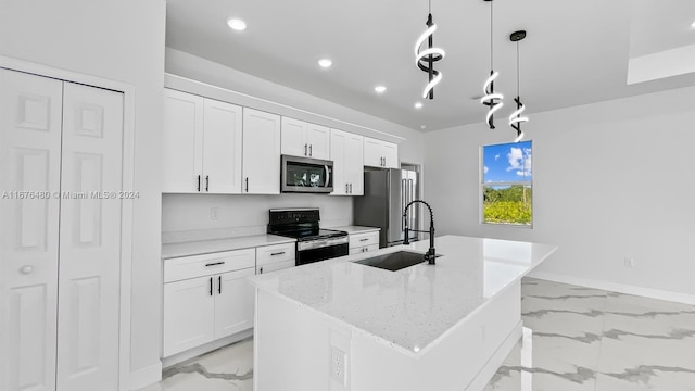 kitchen featuring appliances with stainless steel finishes, sink, a center island with sink, decorative light fixtures, and white cabinetry