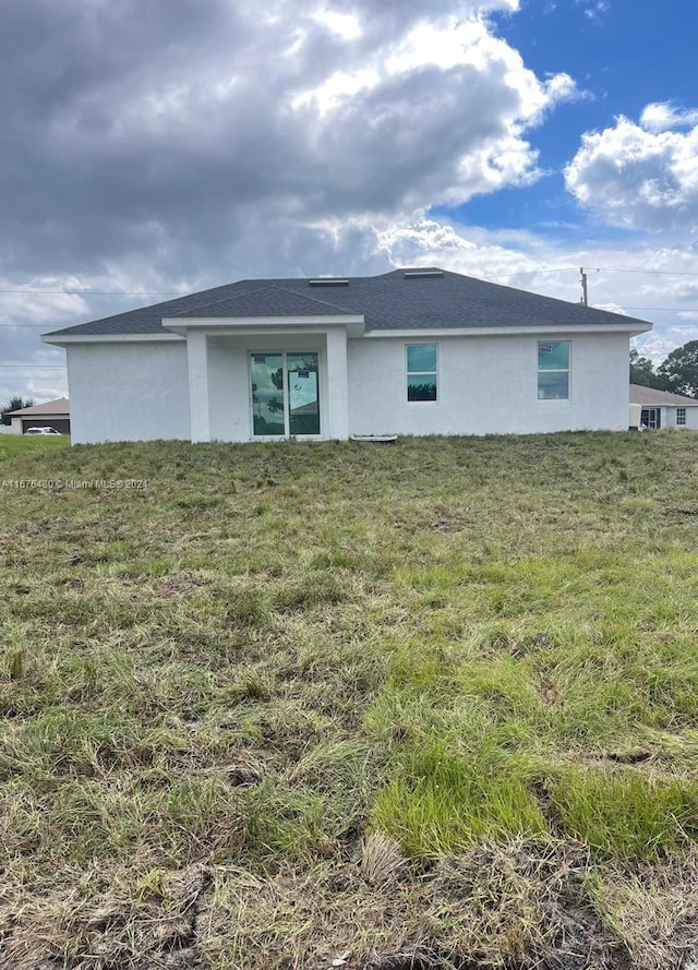 rear view of property featuring a yard