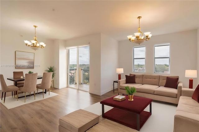 living area featuring baseboards, an inviting chandelier, and wood finished floors