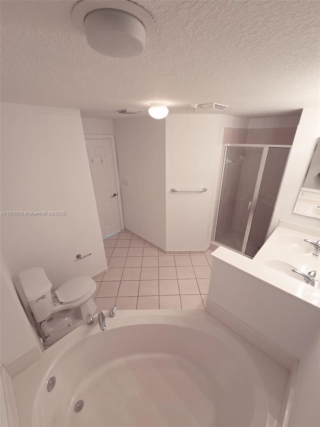 full bathroom with toilet, a stall shower, a sink, a textured ceiling, and tile patterned flooring