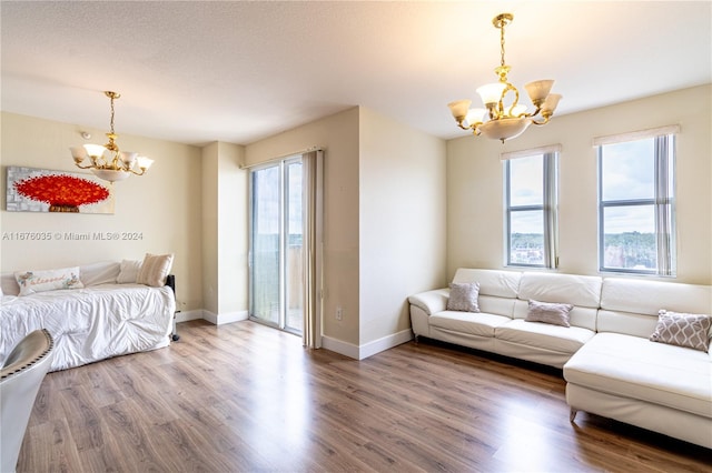 living room with a notable chandelier, hardwood / wood-style flooring, and a textured ceiling