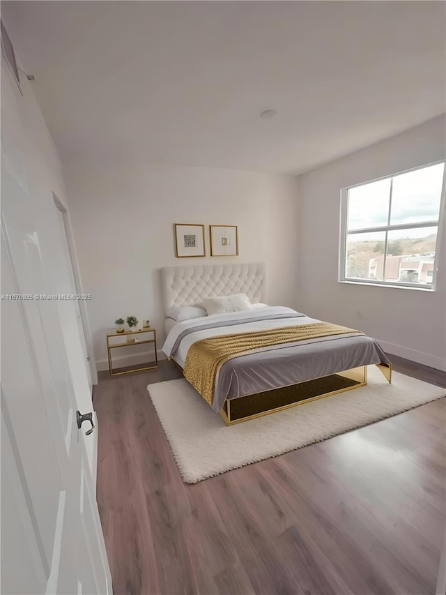 bedroom featuring baseboards and wood finished floors