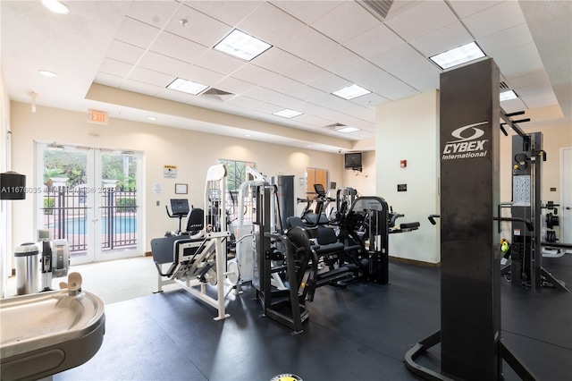 gym with visible vents, french doors, and a paneled ceiling