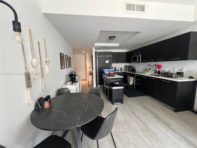 kitchen with light hardwood / wood-style flooring, stainless steel appliances, pendant lighting, and a center island