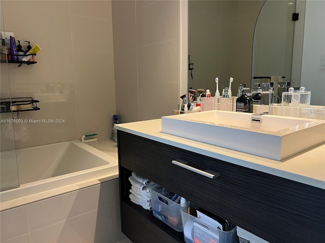 bathroom with vanity and tiled bath