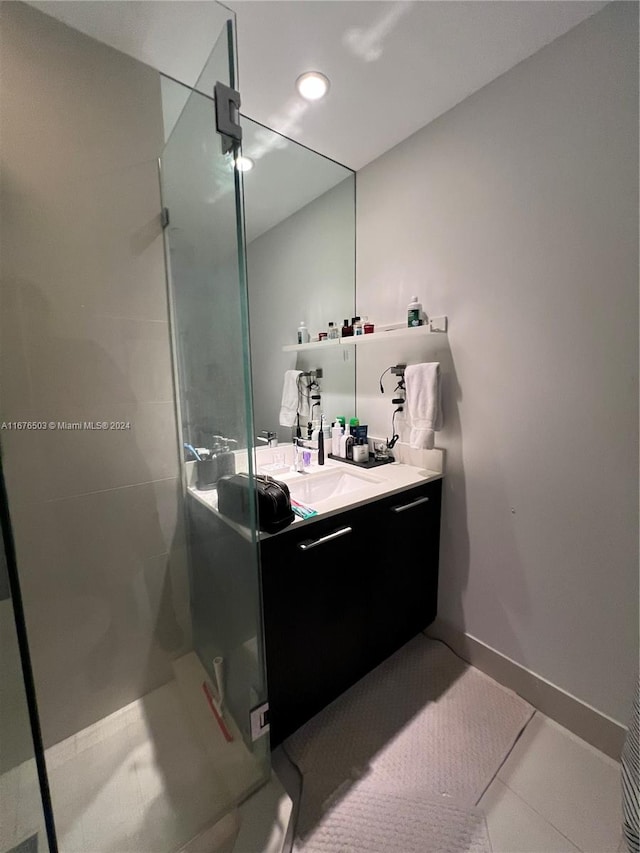 bathroom featuring vanity, a shower with shower door, and tile patterned floors