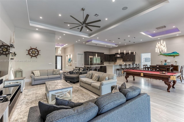 living room featuring a raised ceiling, light hardwood / wood-style floors, billiards, and ceiling fan