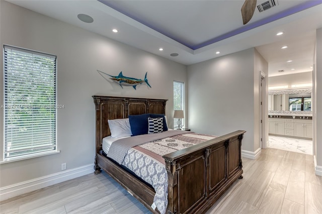 bedroom featuring light hardwood / wood-style floors and ensuite bath