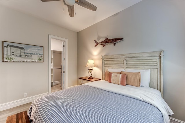 bedroom featuring lofted ceiling, ensuite bathroom, light hardwood / wood-style flooring, and ceiling fan