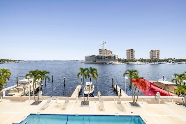 exterior space featuring a water view, a patio, and a community pool