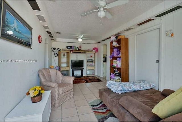 tiled living room featuring a textured ceiling and ceiling fan