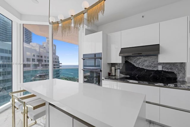 kitchen with extractor fan, black appliances, decorative backsplash, and white cabinets