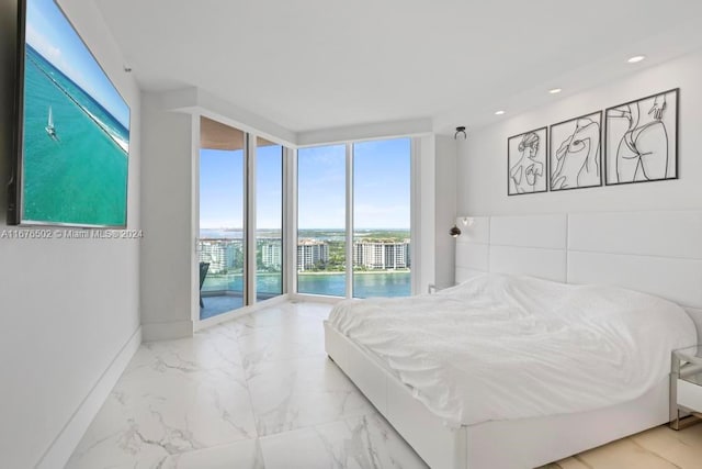 bedroom featuring a water view, multiple windows, and access to outside