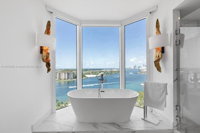 bathroom featuring independent shower and bath, a water view, and a wealth of natural light