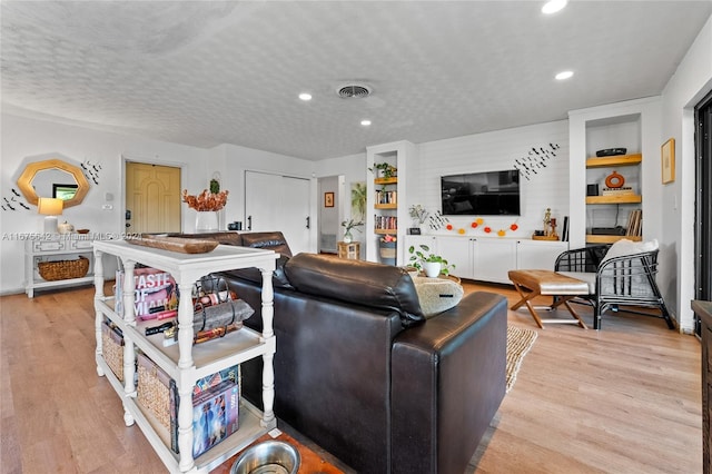 living room featuring a textured ceiling and light wood-type flooring