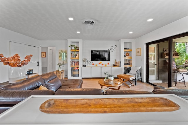 living room featuring a textured ceiling and light hardwood / wood-style flooring